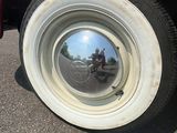 le reflet d'un homme à vélo sur le pneu d'une voiture
