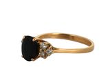 a close up of a gold ring with a black stone