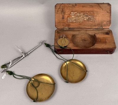 two brass objects sitting on a table next to a wooden box