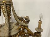 a chandelier that has a candle holder on top of it