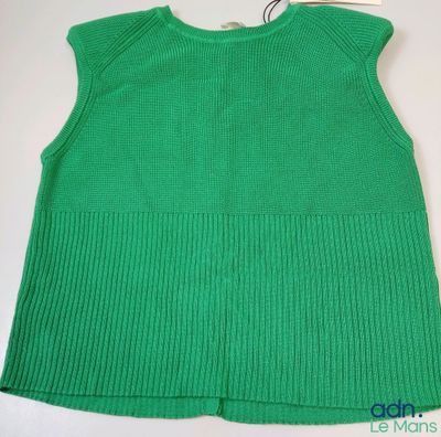 un gros plan d'un pull vert sur un cintre
