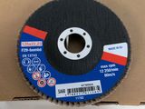 a close up of a metal grinding wheel on a cardboard box