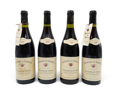 four bottles of wine are lined up on a white surface