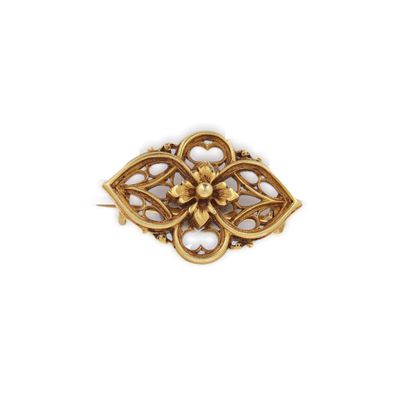 un gros plan d'une broche en or ornée d'une fleur