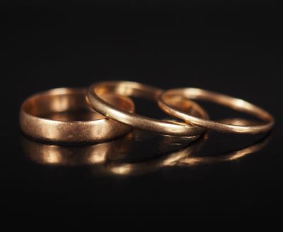 trois alliances en or sur un fond noir