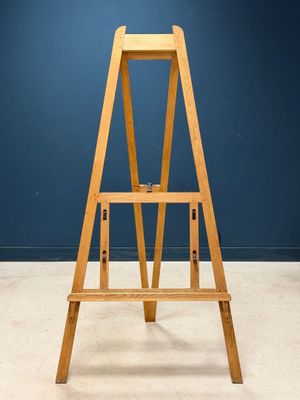 an image of a wooden easer stands against a blue wall