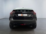 the rear end of a black car in a white room