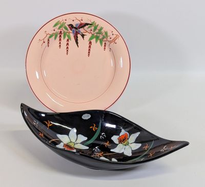 une assiette noire et rose sur laquelle est représenté un oiseau