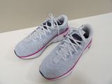 pair of white and pink running shoes sitting on a white surface