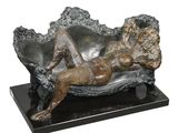 statue of a woman laying on a couch on a black marble base