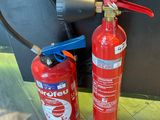 a fire extinguisor and a fire extinguisor next to each other