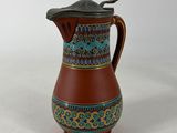 an image of a brown and blue pitcher with a spoon in it