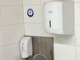 a white paper towel dispenser on the wall above a sink