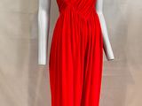 a red dress on a mannequin stand against a white backdrop