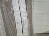 several pieces of furniture are wrapped up in plastic in a warehouse