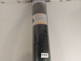 un gros plan sur un rouleau de tissu noir posé sur une surface blanche