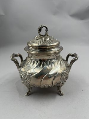 une théière ancienne en métal argenté, avec un couvercle et des anses