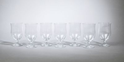 six verres à vin vides alignés sur une surface blanche