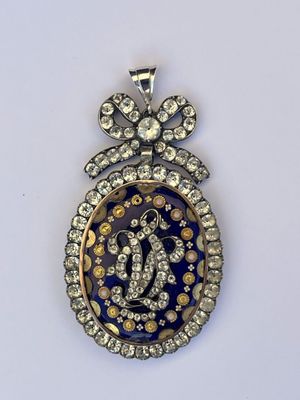 un gros plan d'un pendentif bleu et or orné de diamants