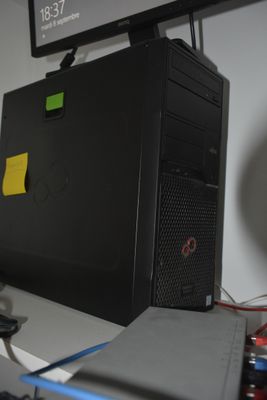 a desktop computer sitting on a desk with a monitor above it