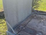 the back end of a trailer with a metal bed and a hose attached to it