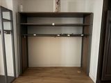 a closet in the corner of a room with a book shelf