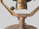 a gold plated clock on a stand on a gray background