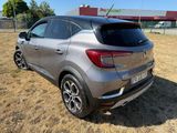 the rear end of a silver car parked in a field
