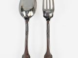 two spoons and a fork on a white surface
