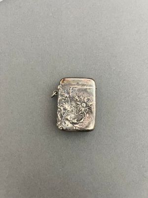 a close up of a silver lighter with a dragon on it
