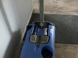 a blue vacuum cleaner that is sitting on the floor
