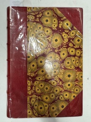 un livre rouge et doré orné d'une multitude de crânes