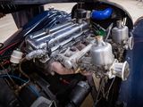a close up of a car engine with a man standing next to it