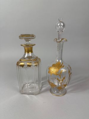 two small glass bottles with gold designs on them
