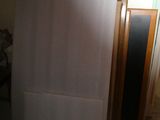 a refrigerator in the corner of a room with a door open