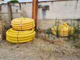 a pile of yellow hoses sitting next to a building