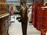 a bronze statue of a person standing in a room