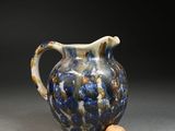 a blue and white pitcher with a cork on the side