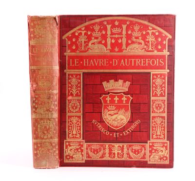 un vieux livre à la couverture rouge posé sur une surface blanche