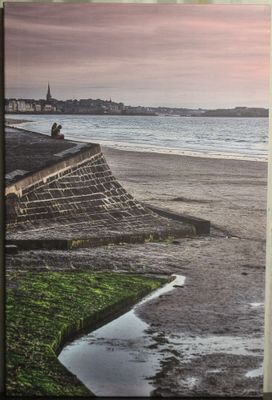 une photo d'un homme assis au bord de la plage