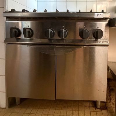 une cuisinière en acier inoxydable dans une cuisine au sol carrelé