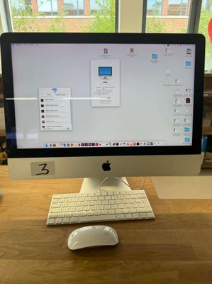 a computer monitor sitting on a desk with a keyboard and mouse