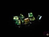 a close up of a group of green crystals on a black surface
