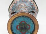 a close up of a vase on a white surface