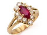 un gros plan d'une bague en or sertie d'un rubis et d'une topaze blanche