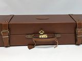 a brown suitcase that is sitting on a white surface