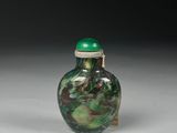 a green and white vase sitting on a white surface