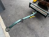 a green tow truck with a yellow handle on the street