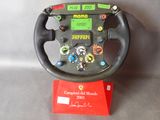 ferrari steering wheel with stickers on display in a display case