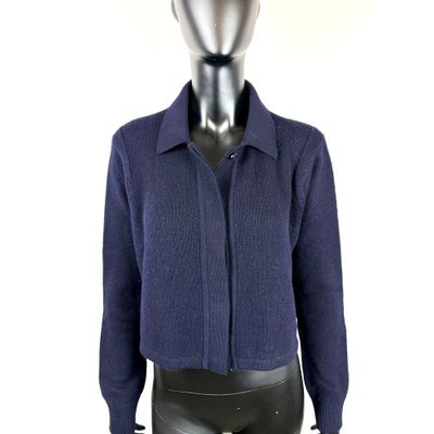 Le mannequin porte un pull bleu et un pantalon en cuir noir.